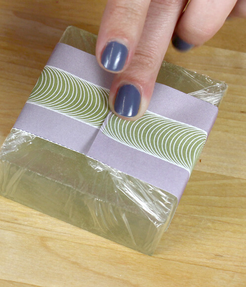 Taping a label to the back of a bar of soap